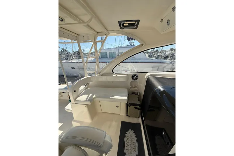 Slide: The Image of 2004 Pursuit 3370 Offshore boat interior with seating and helm, docked at marina. - 35