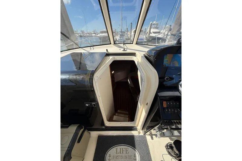 Slide: The Image of 2004 Pursuit 3370 Offshore boat interior with open cabin door, marina view. - 38