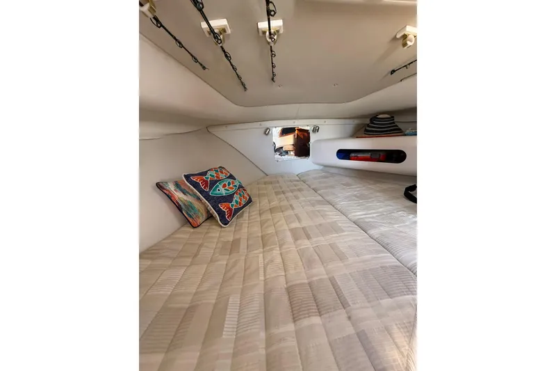 Slide: The Image of 2004 Pursuit 3370 Offshore cabin interior with cozy bedding and colorful pillows. - 43