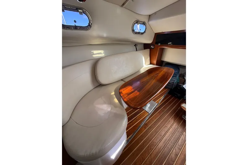 Slide: The Image of 2004 Pursuit 3370 Offshore cabin with elegant seating and wooden table. - 49