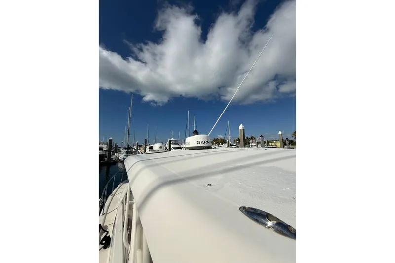 Slide: The Image of 2004 Pursuit 3370 Offshore boat docked under a clear blue sky. - 58