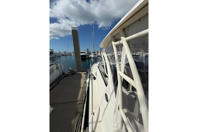Slide: The Image of 2004 Pursuit 3370 Offshore boat docked at marina under blue sky. - 59