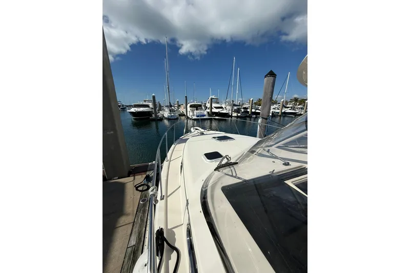 Slide: The Image of 2004 Pursuit 3370 Offshore boat docked at a marina under a clear blue sky. - 60