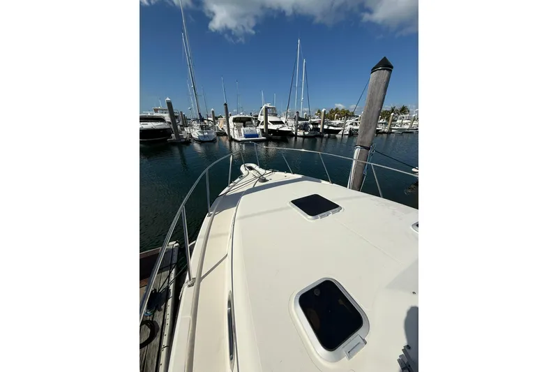 Slide: The Image of 2004 Pursuit 3370 Offshore boat docked at a marina with clear skies. - 61