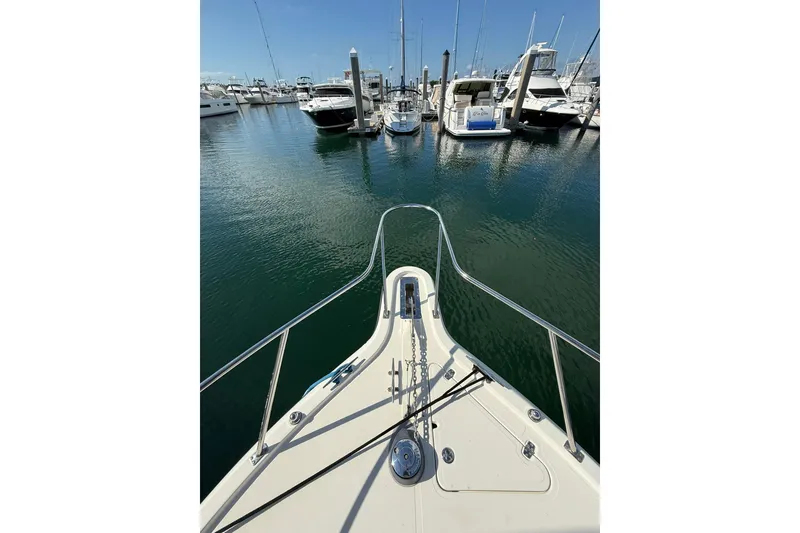 Slide: The Image of Bow view of 2004 Pursuit 3370 Offshore in a marina, surrounded by boats. - 62