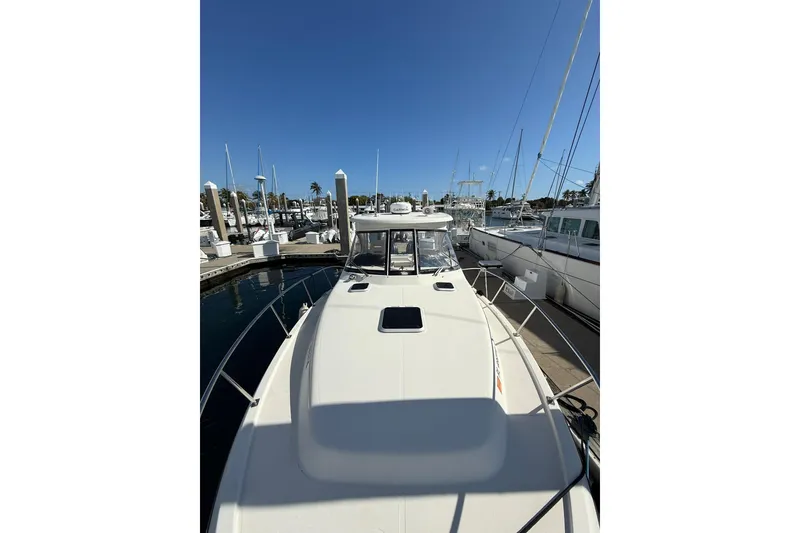 Slide: The Image of 2004 Pursuit 3370 Offshore boat docked at marina under clear blue sky. - 64
