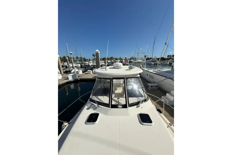 Slide: The Image of 2004 Pursuit 3370 Offshore boat docked at a marina under clear blue skies. - 67