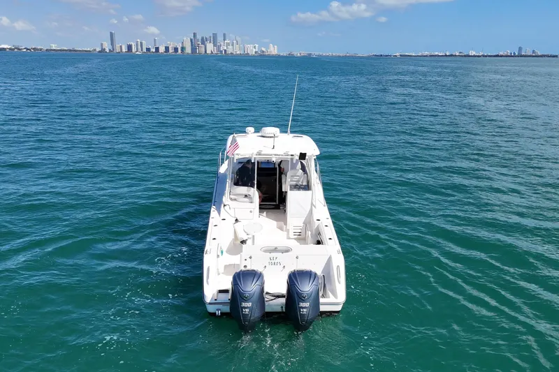Slide: The Image of 2004 Pursuit 3370 Offshore boat on open water with city skyline in background. - 8