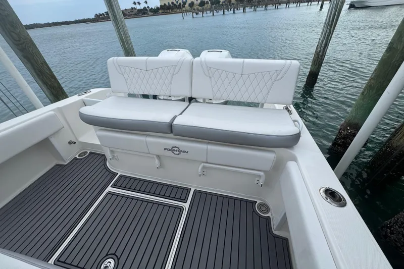 Slide: The Image of 2018 Fountain 34 Center Console boat with white seating and gray deck, docked by water. - 11