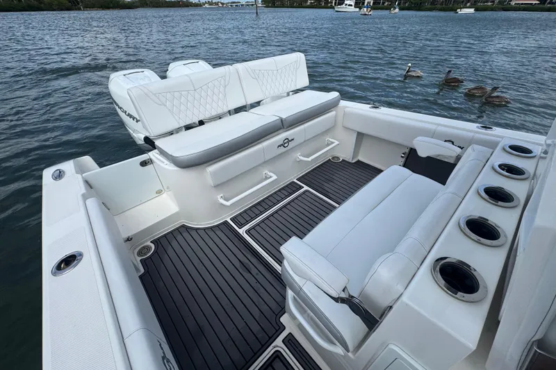 Slide: The Image of 2018 Fountain 34 Center Console boat interior with seating and cup holders on the water. - 14