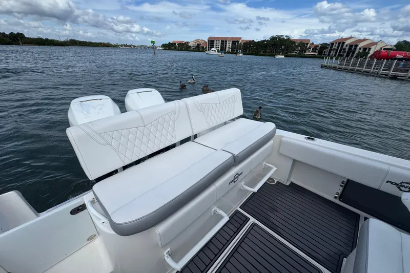 Slide: The Image of 2018 Fountain 34 Center Console boat with white seating, docked on a calm lake. - 16