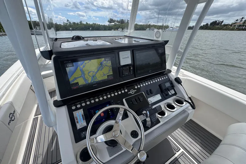 Slide: The Image of 2018 Fountain 34 Center Console boat dashboard with navigation screens and steering wheel. - 18