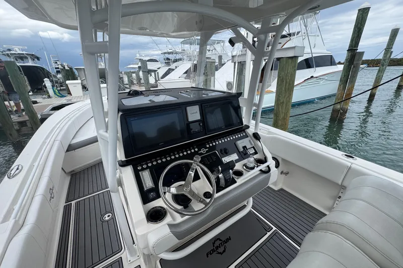 Slide: The Image of 2018 Fountain 34 Center Console boat interior with advanced navigation system at marina. - 3