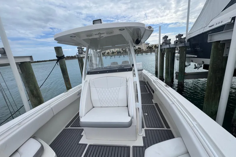 Slide: The Image of 2018 Fountain 34 Center Console boat docked, featuring sleek design and spacious seating. - 7