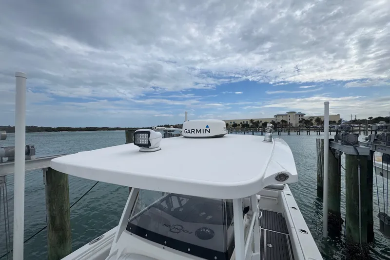 Slide: The Image of 2018 Fountain 34 Center Console boat docked, featuring Garmin equipment under a cloudy sky. - 9