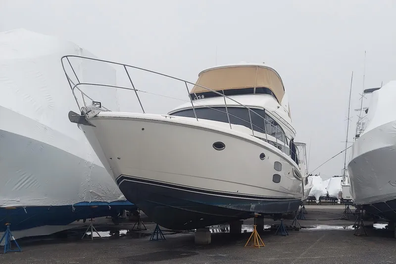 The Image of 2013 Meridian 441 Sedan yacht in storage, surrounded by covered boats. - 0