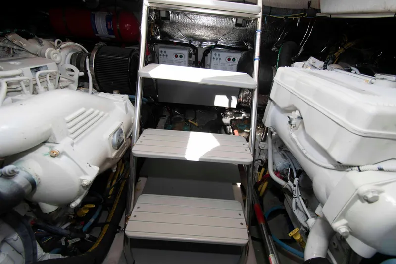 Slide: The Image of Engine room of a 2013 Meridian 441 Sedan yacht, featuring dual engines and a central ladder. - 28