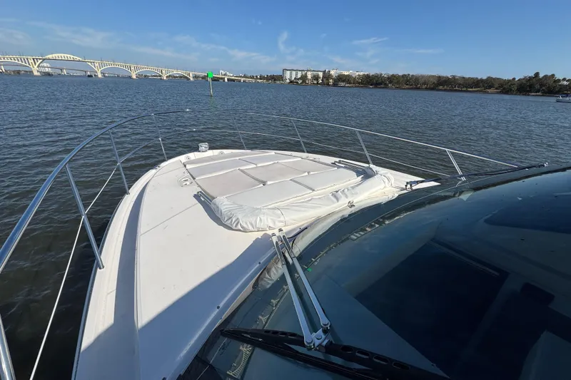 Slide: The Image of 2021 Regal 38 XO yacht on calm water with bridge in background. - 12