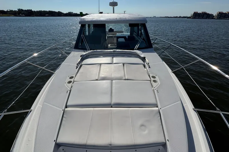 Slide: The Image of 2021 Regal 38 XO yacht with sunpad on calm water. - 13
