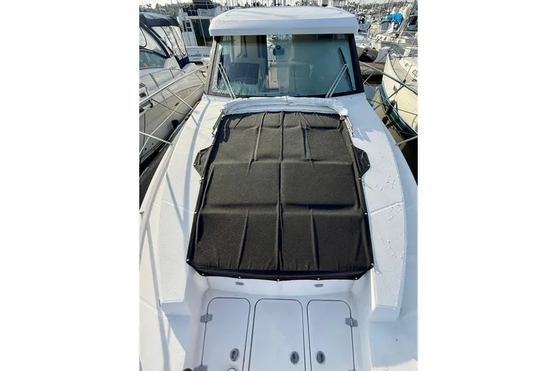 Slide: The Image of 2021 Regal 38 XO yacht with black sunpad cover on deck, docked at marina. - 14