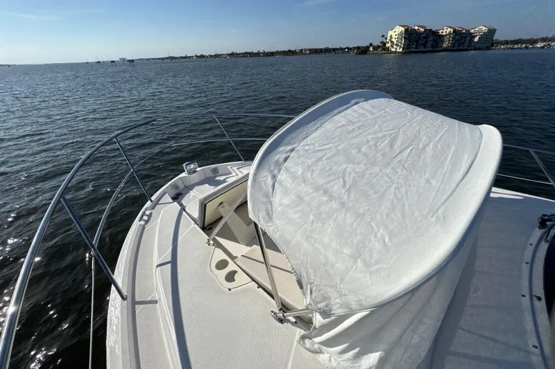 Slide: The Image of 2021 Regal 38 XO yacht bow with sunshade on calm water. - 15