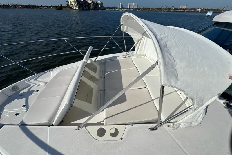 Slide: The Image of 2021 Regal 38 XO boat with sunshade and cushioned seating on deck. - 16