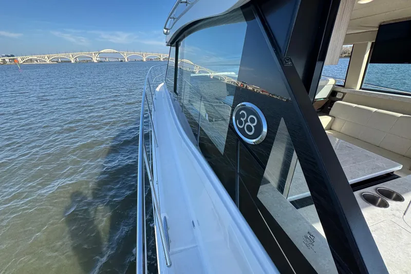 Slide: The Image of 2021 Regal 38 XO yacht cruising on a sunny day near a bridge. - 17