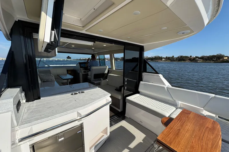 Slide: The Image of 2021 Regal 38 XO yacht interior with modern seating and scenic water view. - 21