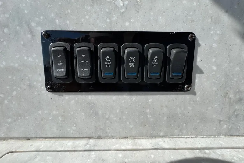 Slide: The Image of Control panel on a 2021 Regal 38 XO boat with labeled switches. - 25