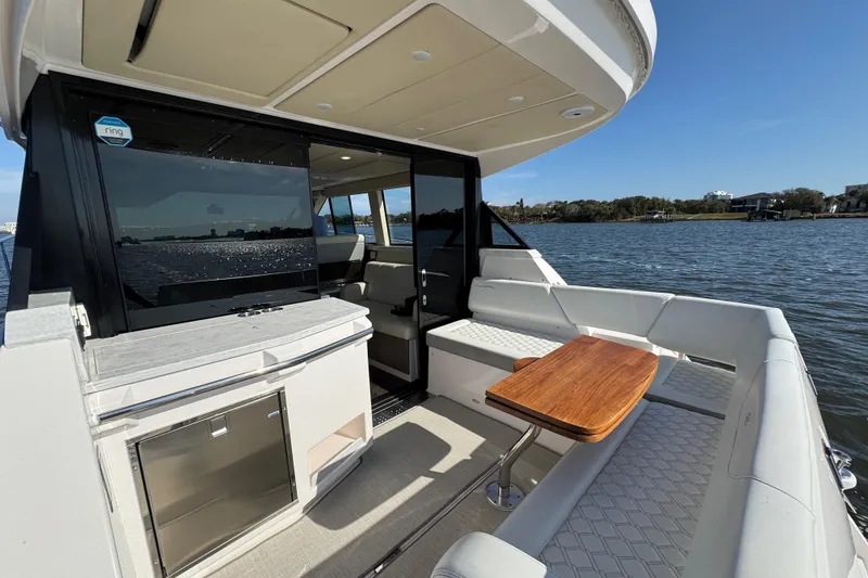 Slide: The Image of 2021 Regal 38 XO yacht interior with seating, table, and water view. - 28