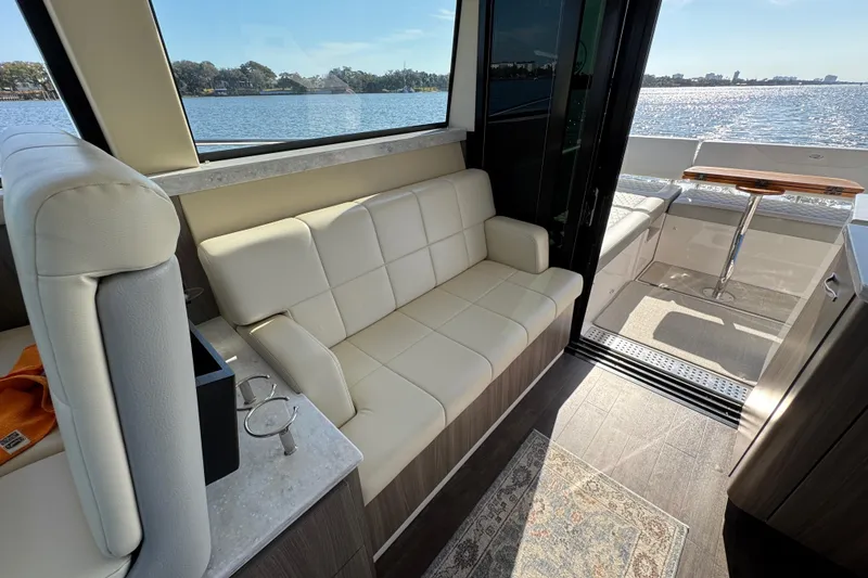 Slide: The Image of Luxurious interior of 2021 Regal 38 XO yacht with white seating and scenic water view. - 49