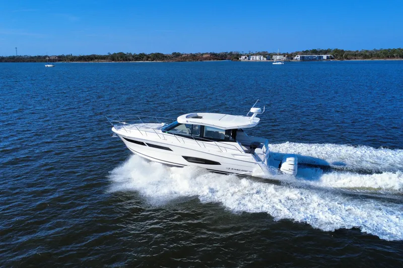 Slide: The Image of 2021 Regal 38 XO yacht cruising on open water under clear blue skies. - 5
