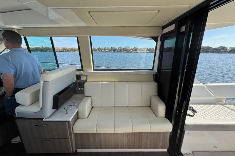 Slide: The Image of Interior of 2021 Regal 38 XO yacht with white seating and scenic water view. - 50