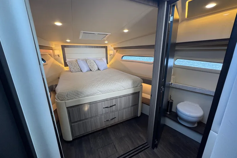 Slide: The Image of Luxurious 2021 Regal 38 XO yacht cabin with bed and compact bathroom. - 53