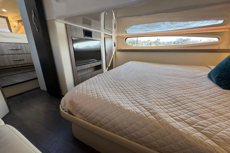 Slide: The Image of Interior of 2021 Regal 38 XO yacht bedroom with bed, TV, and window view. - 62