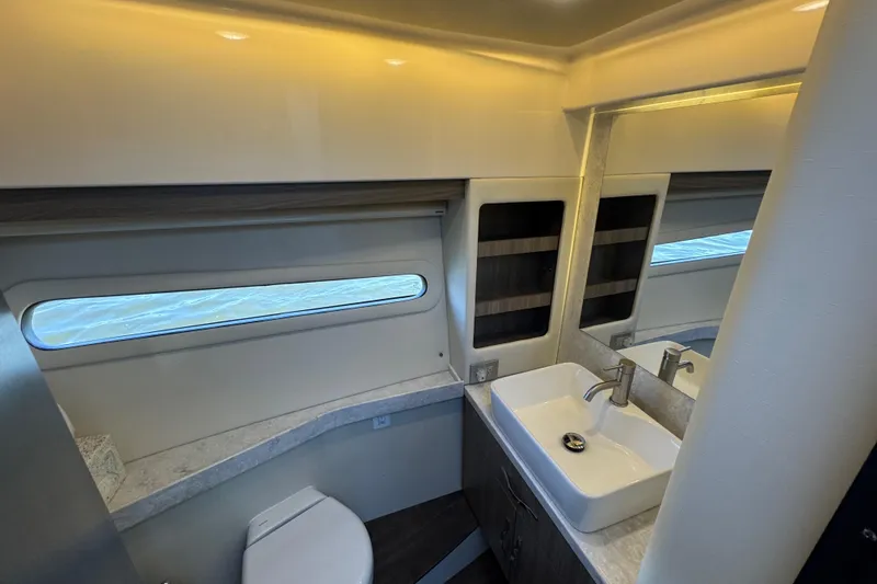 Slide: The Image of 2021 Regal 38 XO yacht bathroom with modern sink, toilet, and window view. - 65