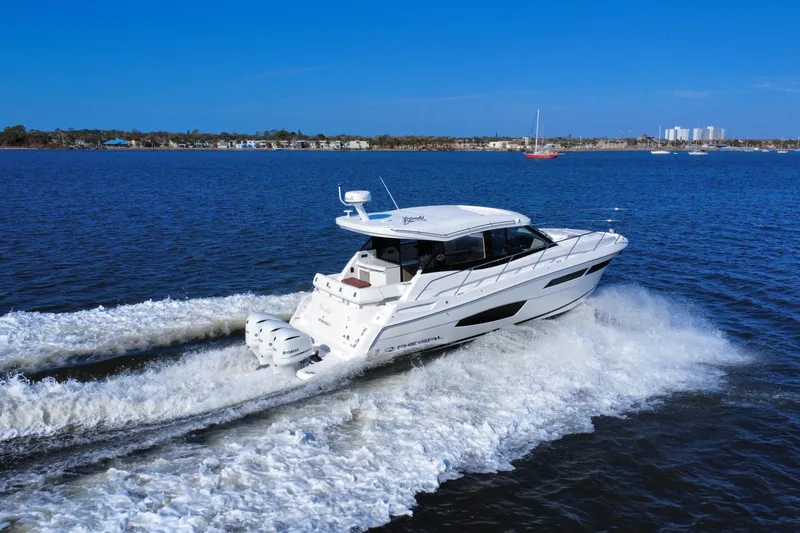 Slide: The Image of 2021 Regal 38 XO yacht cruising on open water, creating a dynamic wake. - 7
