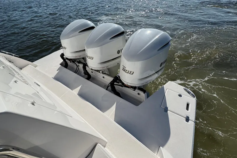Slide: The Image of Triple Yamaha outboard engines on a 2021 Regal 38 XO boat in water. - 76