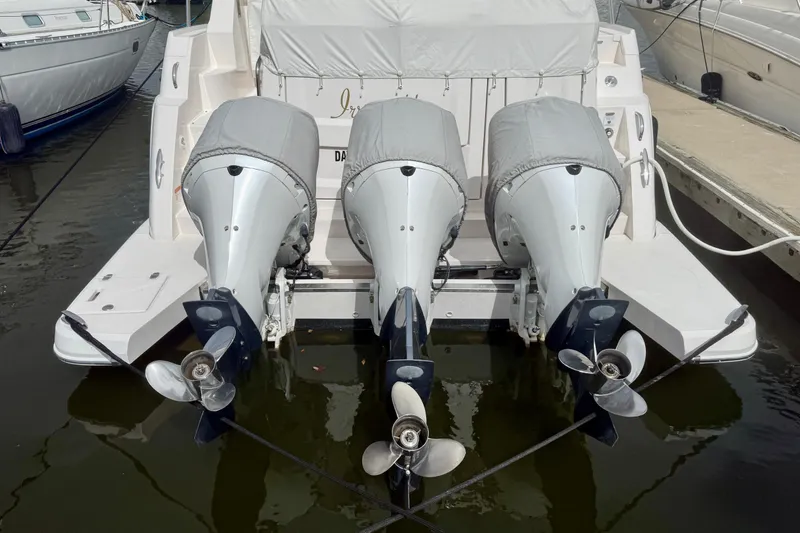 Slide: The Image of 2021 Regal 38 XO boat with triple outboard engines at dock. - 78
