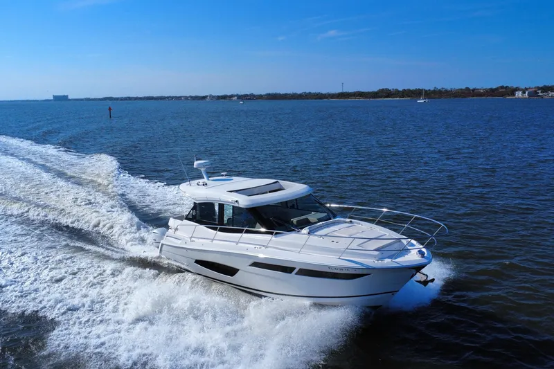 Slide: The Image of 2021 Regal 38 XO yacht cruising on open water under clear blue skies. - 8