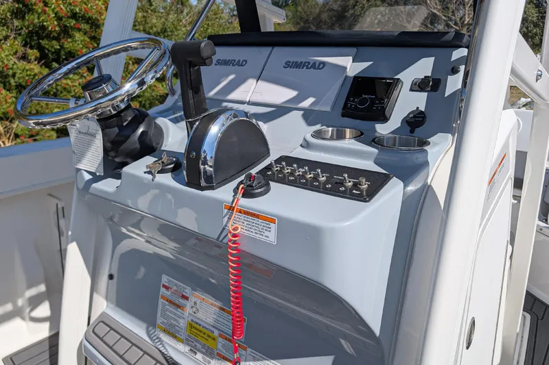 Slide: The Image of 2025 Bayliner Trophy T22CC helm with steering wheel, controls, and Simrad electronics. - 14