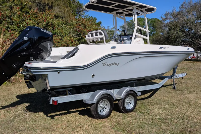 Slide: The Image of 2025 Bayliner Trophy T22CC boat on trailer, parked on grass, with outboard motor. - 5