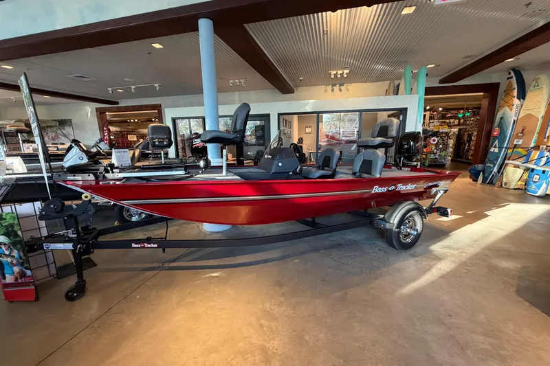 The Image of 2026 Tracker Bass Tracker Classic XL boat displayed in a showroom, featuring a sleek red design. - 0