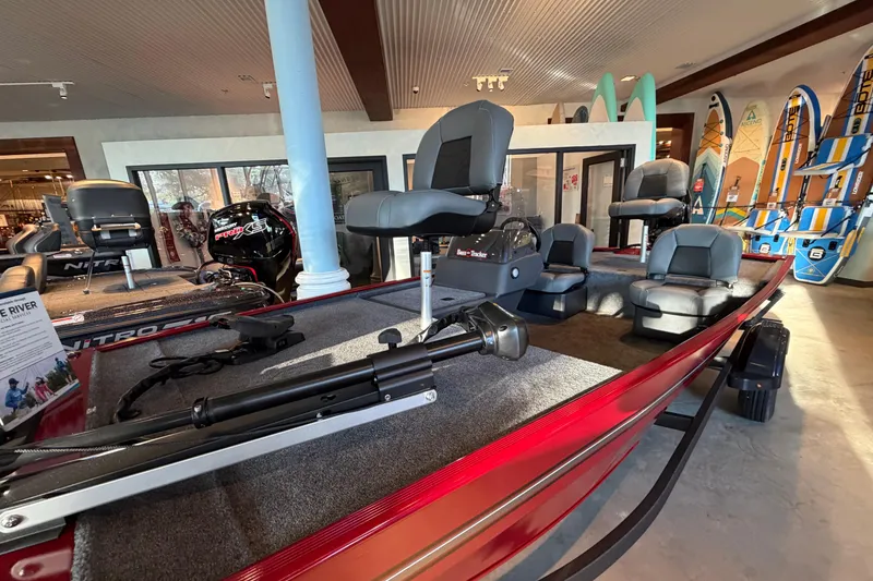 Slide: The Image of 2026 Tracker Bass Tracker Classic XL boat displayed in a showroom with seating and equipment. - 2