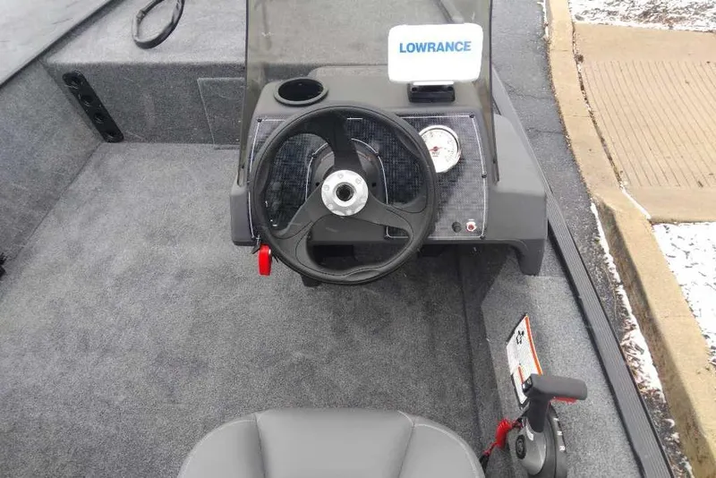 Slide: The Image of 2026 Tracker Bass Tracker Classic XL boat cockpit with steering wheel and Lowrance display. - 2
