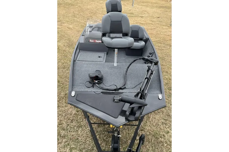 Slide: The Image of 2026 Tracker Bass Tracker Classic XL boat with seating and fishing equipment on grass. - 4