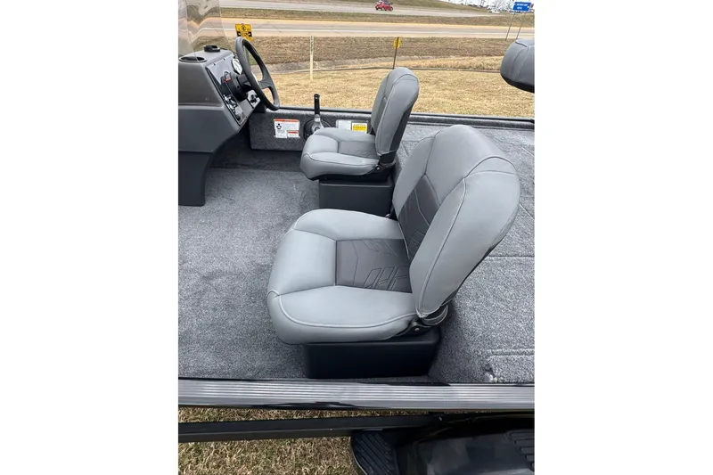 Slide: The Image of 2026 Tracker Bass Tracker Classic XL boat interior with gray seats and steering console. - 9