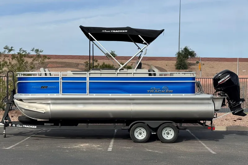Slide: The Image of 2026 Sun Tracker Fishin' Barge 20 DLX pontoon boat on trailer, side view. - 1