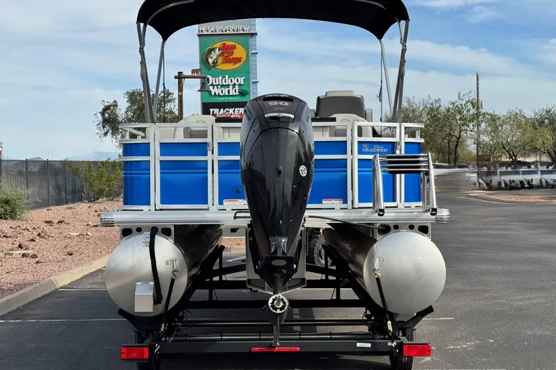 Slide: The Image of 2026 Sun Tracker Fishin' Barge 20 DLX pontoon boat with outboard motor in parking lot. - 3