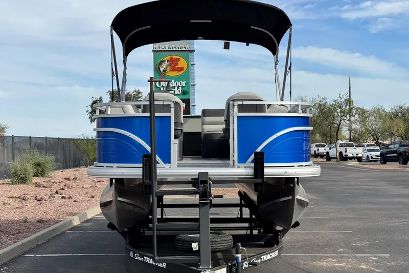 Slide: The Image of 2026 Sun Tracker Fishin' Barge 20 DLX pontoon boat in parking lot, rear view. - 2